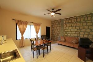 a living room with a ceiling fan and a table and chairs at Plaza Magdalena Hotel in Copan Ruinas