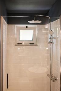 a bathroom with a shower with a tv on the ceiling at BABhouse Villa Jardim das Laranjeiras in Nagoselo do Douro