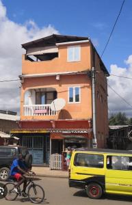 a person riding a bike in front of a building at Micaval Residential in São Tomé