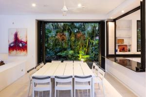 アナポイマにあるSplendid 5BR Villa at Mesa de Yeguasのテーブルと椅子と大きな窓のあるダイニングルーム