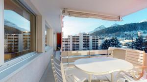 a white table and chairs on a balcony with a view at Apartment Skyline 307 in St. Moritz