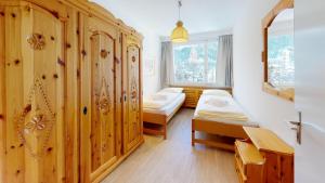 a bedroom with two beds and a wooden wall at Apartment Skyline 307 in St. Moritz