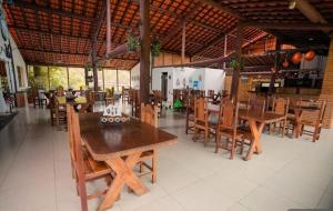 a restaurant with wooden tables and chairs in a room at Chalé Paraíso das Nascentes in Salesópolis