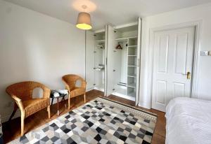a bedroom with a bed and two chairs and a door at Lawnfield Lodge in Newcastle