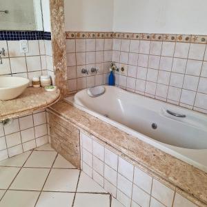 a bathroom with a bath tub and a sink at Porto Mar de Búzios in Búzios +51 photos