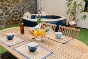 un tavolo di legno con una ciotola di frutta sopra di Villa Estelle - 10 voyageurs a Saint-Pierre Altre 25 foto