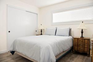 a white bedroom with a bed and a window at Beach Escape, 2 Blocks Away, Sleeps 6 in Seaside