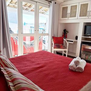 a bedroom with a red bed with towels on it at Porto Mar de Búzios in Búzios