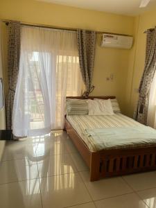 ein Schlafzimmer mit einem Bett und einem Fenster in der Unterkunft Luxury Tema community 25 gated1-bedroom apartment - Fivehills homes in Tema + 12 Fotos