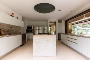 アナポイマにあるBeautiful 4BR Villa at Mesa de Yeguasの白いキャビネットと大きな島のある広いキッチンが備わります。 +17枚の写真