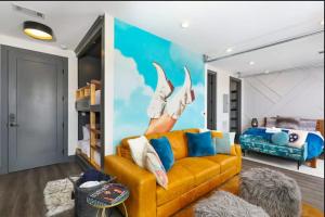 a living room with a yellow couch and a bed at Muse- Morgan Wallen Speakeasy and Giant Balcony in Nashville