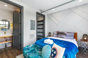 a bedroom with a large bed with a blue comforter at Muse- Morgan Wallen Speakeasy and Giant Balcony in Nashville