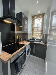 a kitchen with a sink and a washing machine at City Life Access Everywhere in London