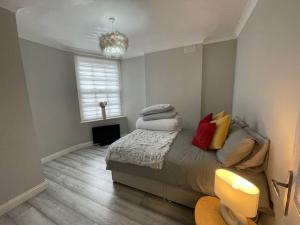 a bedroom with a bed with pillows and a chandelier at City Life Access Everywhere in London