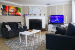 a living room with a couch and a table and a tv at The Trace Elegant Eclectic Home with patio in Smyrna Ga in Smyrna