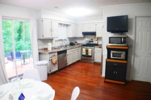 a kitchen with stainless steel appliances and white cabinets at The Trace Elegant Eclectic Home with patio in Smyrna Ga in Smyrna
