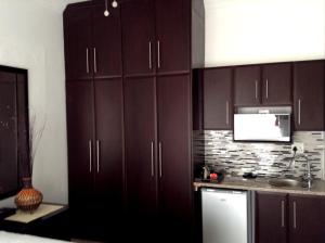 a kitchen with dark brown cabinets and a sink at Majestic in Kokstad