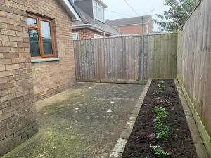 a backyard with a fence and a garden at Moredon Bungalow in Swindon