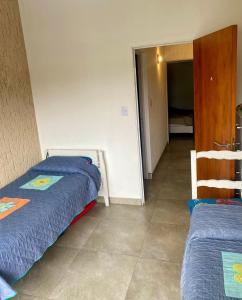 ein Schlafzimmer mit zwei Betten und ein Flur in der Unterkunft Magdalena in Santa Rosa de Calamuchita