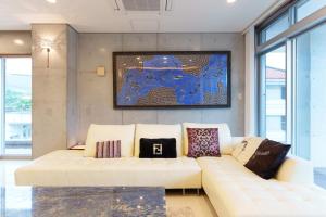 a living room with a white couch with pillows at Villa Sirene Ishigaki in Ishigaki Island +92 photos