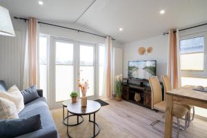 Una sala de estar con un sofá azul y una mesa. en Ostseecamp Ostseebrise, en Scharbeutz