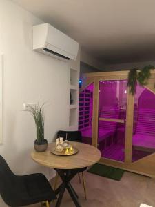 AvolsheimにあるMagnifique gîte avec jacuzzi et sauna privatifsのダイニングルーム(テーブル、紫色の照明付)