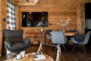 a living room with a table and chairs in a cabin at Mountain Shelter Salamandra in Kościelisko