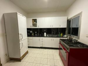 a kitchen with white cabinets and a stove top oven at Appartement luxueux Ngousso Yaoundé in Yaoundé