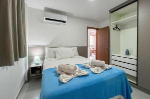 a bedroom with a blue bed with towels on it at Flat Genebra Bessa 2 Quartos 4 Pessoas 150m Praia in Tambaú +18 photos