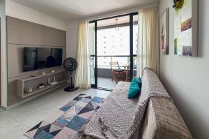 a living room with a couch and a flat screen tv at Flat Genebra Bessa 2 Quartos 4 Pessoas 150m Praia in Tambaú