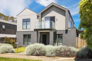 una gran casa blanca con balcón en Inlet Paradise, en Rhyll