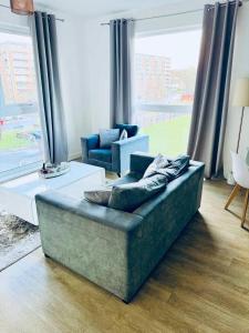 a living room with a couch and a large window at Cosy City Apartment in Manchester in Manchester