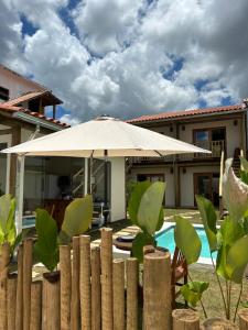 un paraguas blanco delante de una casa en Chalé Pequeno Oásis, en Tiradentes