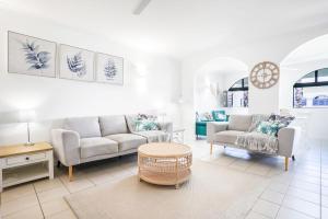 a living room with two couches and a coffee table at Dasheri at Mango Lagoon Resort in Palm Cove