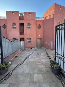 an empty courtyard of a red building with a gate at Villa Sharm El-Sheikh in Sharm El Sheikh