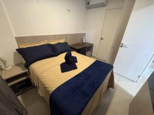 a bedroom with a large bed with a blue blanket at Fortaleza VG Fun Flats Sol e Mar in Fortaleza +18 photos
