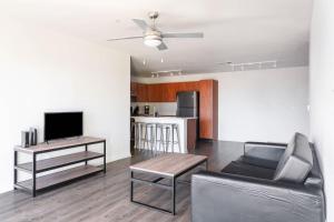 オースティンにあるModern Condo with Pool Gym Workspaces & BBQのソファとテーブルとテレビのあるリビングルーム