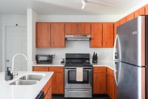 オースティンにあるModern Condo with Pool Gym Workspaces & BBQのキッチン(木製キャビネット、ステンレス製の冷蔵庫付) +31枚の写真