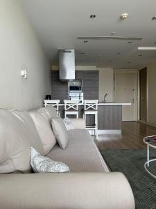 Una sala de estar con un sofá blanco y una cocina. en Ottomare Suites sea, view, pool, gym, en Estambul 47 fotos más