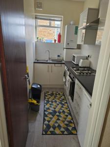 a small kitchen with a sink and a stove at Stylish 1 bed apartment in Watford