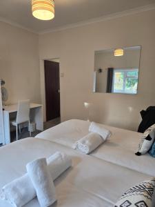 a bedroom with a large white bed with towels on it at Stylish 1 bed apartment in Watford