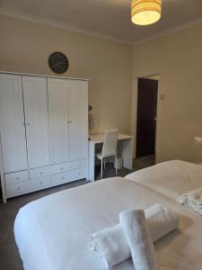 a bedroom with a large white bed with towels on it at Stylish 1 bed apartment in Watford +4 photos