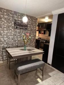 a kitchen with a table with a vase of flowers on it at Departamento hogareño Teziutlán in Teziutlán