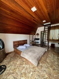 una camera da letto con un letto e un soffitto in legno di Chales Trevo a São João del Rei