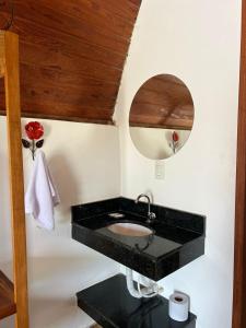 bagno con lavandino nero e specchio di Chales Trevo a São João del Rei