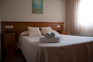 1 dormitorio con 1 cama con 2 toallas en Hostal Maribel, en Almería
