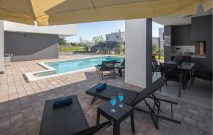 un patio avec une table et des chaises et une piscine dans l'établissement 4 Bedroom Nice Home In Kastelir, à Kaštelir