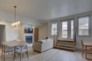 a living room with a couch and a table and chairs at La Pinsonnière in La Malbaie