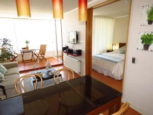 a hotel room with a bed and a living room at Alto Coraceros Apartment in Viña del Mar