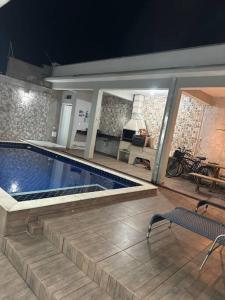een zwembad in een huis met twee stoelen bij Martin de Sá-200 metros da praia in Caraguatatuba